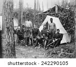 Four union officers in front of tent, with two Africans-American during the Petersburg Campaign. Many former slaves, emancipated in 1863, were employed a servants to Union officers. August, 1864.