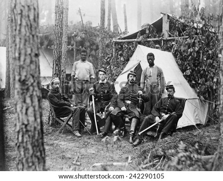 Four union officers in front of tent, with two Africans-American during the Petersburg Campaign. Many former slaves, emancipated in 1863, were employed a servants to Union officers. August, 1864.