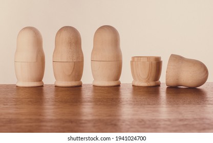 Four Unpainted Nesting Dolls In A Row, Three Closed, One Open. Soft Brown Colors, Wooden Materials.