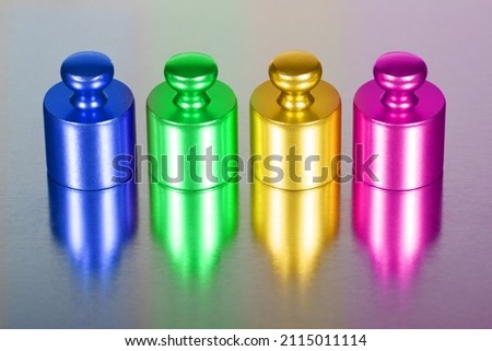 Four weights stand on a reflective background.