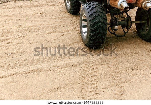 Four wheeled ATV parked on\
the sand