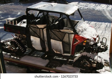 Four Wheeler Snowmobile Loaded On Trailer Bed	