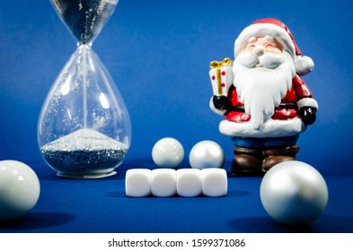 Four White Blank Blocks With Santa Clause Figure And Running Hour Glass In A Conceptual Image For New Year.