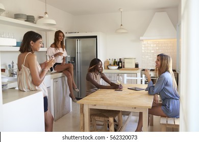 Four Women Drinking Wine In Kitchen During A GirlsÃ¢?? Night In