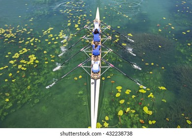 Four Women Rowing On The Tranquil Lake