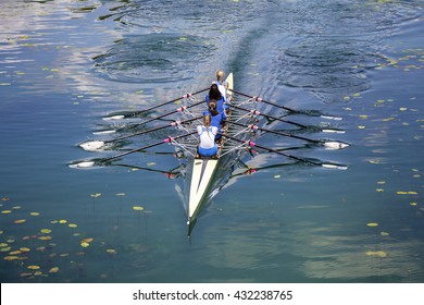 Four Women Rowing On The Tranquil Lake
