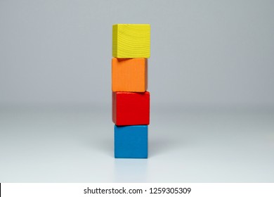 Four Wooden Childrens Blocks Of Different Colors Stacked In A High Tower