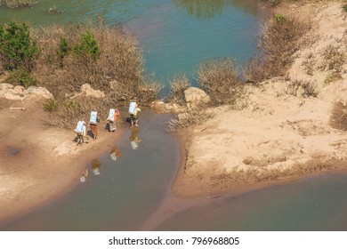 Four Workers Carry Sandbag Crossing The Canal In Vang Vieng,Laos.December-2008.