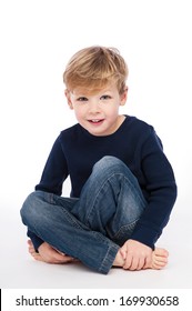 Four Year Old Boy Sitting Cross Legged. Studio Shot On White Background.