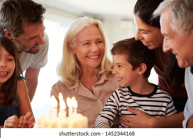 Four Year Old White Boy And His Family Celebrating With A Birthday Cake And Lit Candles, Close Up