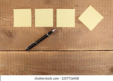 four yellow notes on a wooden table - Shutterstock ID 1257716458