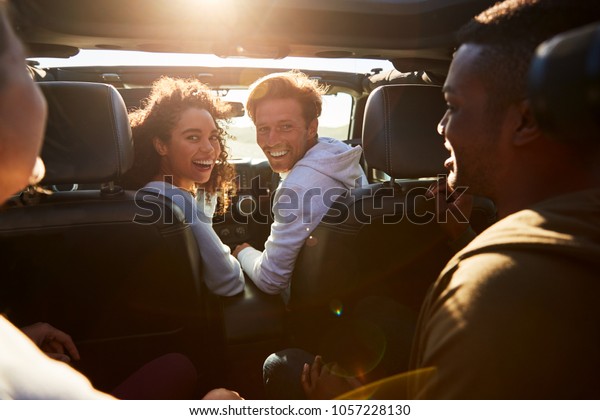 Four\
young adult friends travelling together in a\
car