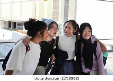 Four young attractive Asian group woman friends colleagues students talk walk discuss mingle outdoors backpack handphone outdoor notebook urban building cityscape look happy fun