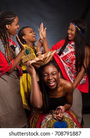Four young beautiful African fashion models have fun and laughing in traditional dress!