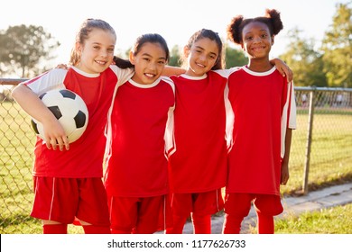 Four Young Girls In Football Strip Looking To Camera Smiling