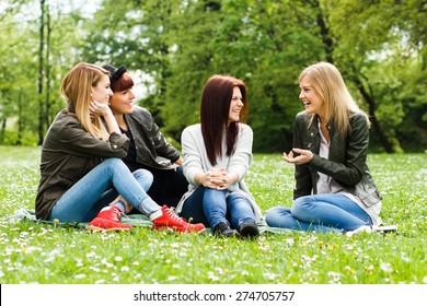 Four Young Girls Sitting In The Park And Talking About Something.Friends Talking