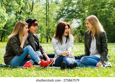 Four Young Girls Sitting In The Park And Talking.Did You Hear?!