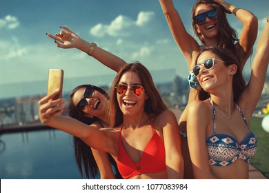 Four Young Women In A Penthouse Near The Pool Doing Selfie In A Bikini