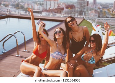 Four Young Women In A Penthouse Near The Pool Doing Selfie In A Bikini