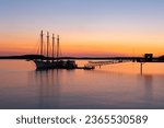 Four-mast sailboat anchored at the pier in Frenchman Bay during a pink and orange sunrise, Bar Harbor, Maine, USA
