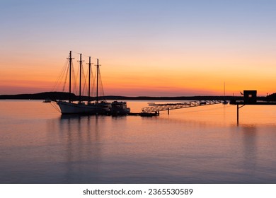 Four-mast sailboat anchored at the pier in Frenchman Bay during a pink and orange sunrise, Bar Harbor, Maine, USA - Powered by Shutterstock