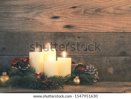 Fourth Advent candle, Christmas background with four Advent candles on a rustic wooden wall