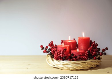 Fourth advent with four red candles, all are lighted, decorated in a natural willow wicker wreath with artificial berries, holiday arrangement, copy space, selected focus, narrow depth of field  - Powered by Shutterstock