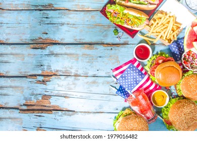 Fourth Of July, Memorial Day, USA Independence Day Concept. Patriotic, American Traditional Food. Picnic Party With Watermelon, Burgers, Hot Dogs, Drinks, Blue Wooden Outdoor Table Background