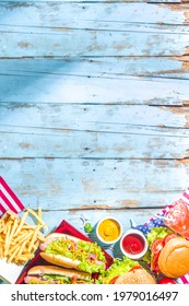 Fourth Of July, Memorial Day, USA Independence Day Concept. Patriotic, American Traditional Food. Picnic Party With Watermelon, Burgers, Hot Dogs, Drinks, Blue Wooden Outdoor Table Background