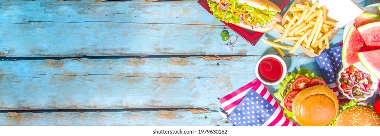 Fourth Of July, Memorial Day, USA Independence Day Concept. Patriotic, American Traditional Food. Picnic Party With Watermelon, Burgers, Hot Dogs, Drinks, Blue Wooden Outdoor Table Background