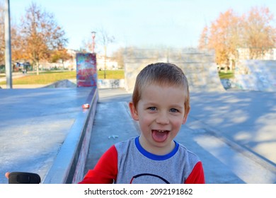 A four-year-old handsome boy looks straight into the camera and stuck out his tongue. Portrait of a blond cocky boy. 