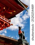 Fox god statue against blue sky at Fushimi Inari Taisha in Autumn season, Kyoto, Japan.