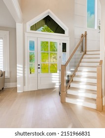 Foyer Of A Lovely Home With Hard Wood Floors Staircase And Colorful Windows