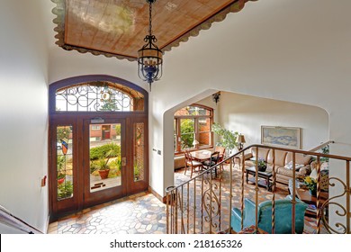 Foyer in old residential building in Downtown, Seattle. Mosaic tile floor, decorated ceiling and wooden entrance door together with wrought iron railings merge a visitor into historic atmosphere