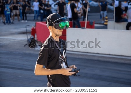 FPV drone pilot controlling his drone in sports car event, speed junkie, Itatiba, São Paulo, Brazil