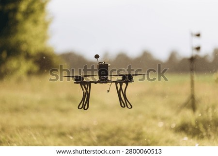 Fpv drone quadcopter performing a test flight against a blurred background, representing modern warfare technology and training