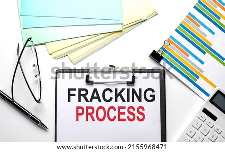 FRACKING PROCESS text on a paper sheet with chart,color paper and calculator
