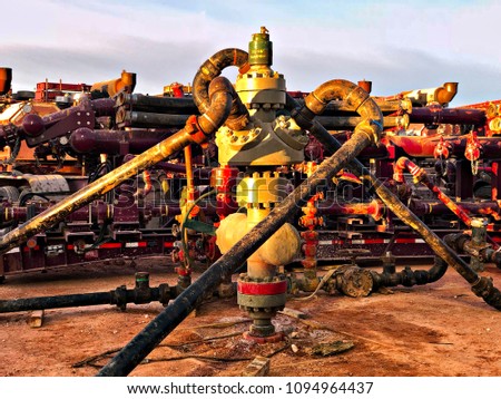 Fracking, well head connected to fracking pumps.