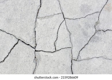 suelo de acera de hormigón fracturado, superficie de cemento grunge gris agrietada en pedazos , efecto de terremoto causa daño al suelo, fondo de textura abstracto, vista superior de cierre