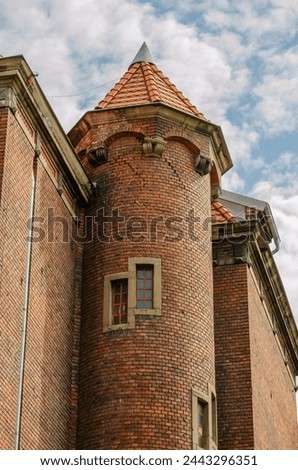 fragment of an annex in the form of a turret, rotunda, made of red brick and with a pointed roof, old building