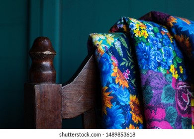 A Fragment Of The Back Of A Chair On Which A Patchwork Quilt Is Folded In Three Folds 