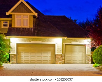 Fragment Of A Big Luxury House With The Triple Garage Doors At Dusk, Night Time.