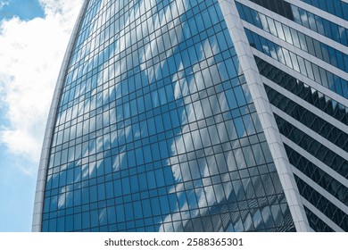 Fragment of a building and windows of a skyscraper. The Evolution Tower in the Moscow-City business center. Fragment of a spiral skyscraper against the sky.