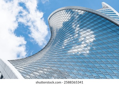 Fragment of a building and windows of a skyscraper. The Evolution Tower in the Moscow-City business center. Fragment of a spiral skyscraper against the sky.