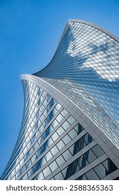 Fragment of a building and windows of a skyscraper. The Evolution Tower in the Moscow-City business center. Fragment of a spiral skyscraper against the sky.