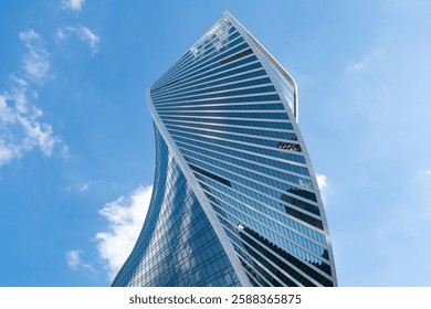 Fragment of a building and windows of a skyscraper. The Evolution Tower in the Moscow-City business center. Fragment of a spiral skyscraper against the sky.