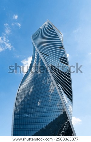 Fragment of a building and windows of a skyscraper. The Evolution Tower in the Moscow-City business center. Fragment of a spiral skyscraper against the sky.