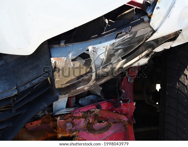 A fragment\
of a car with a broken headlight and a dented rusty bumper. Car\
after an accident. Closeup\
photo