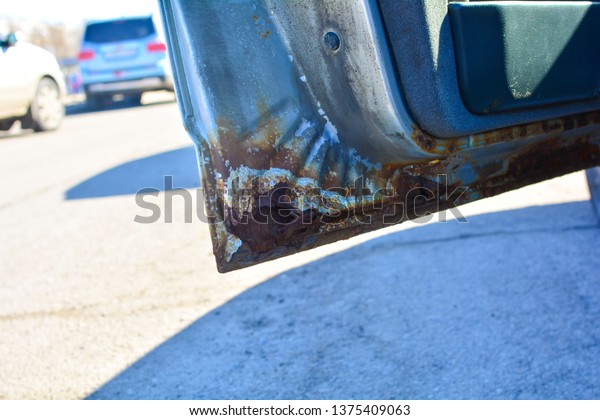 Fragment of a car with rust. The car body\
element is corroded. Concept: corrosion resistance, car body\
repair, rust\
protection.