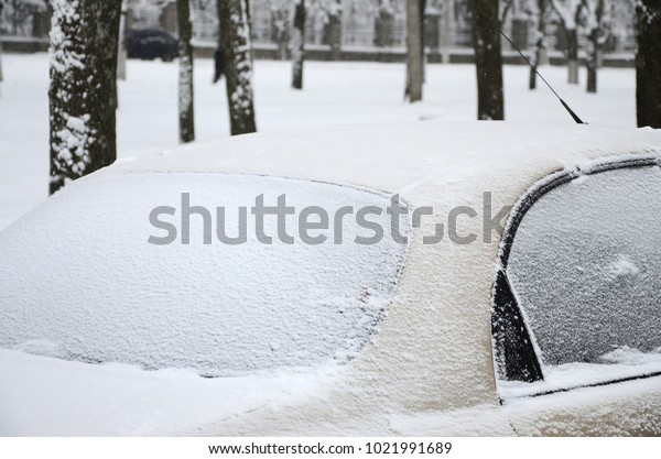 Fragment of the car\
under a layer of snow after a heavy snowfall. The body of the car\
is covered with white\
snow